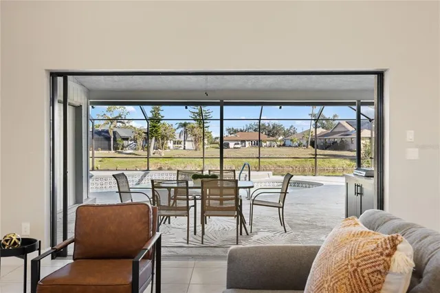 a dining room with furniture a chandelier and a floor to ceiling window