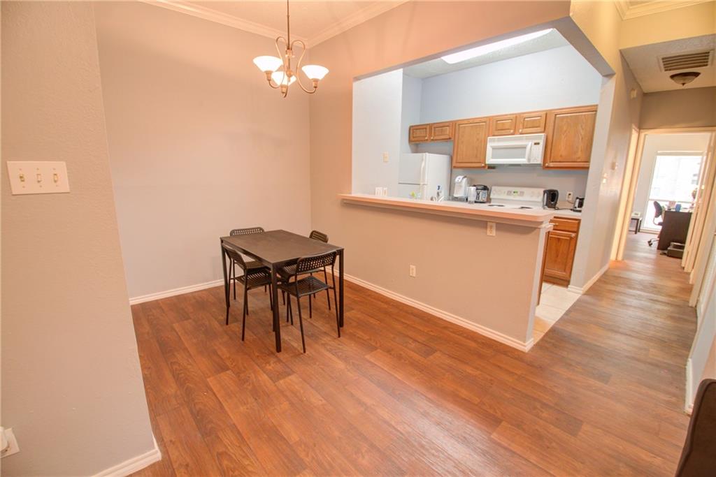 2606 Rio Grande Street, Unit 101 Austin, TX 78705 - Photo 14 of 24 a open kitchen with stainless steel appliances granite countertop a stove top oven a sink dishwasher a dining table and chairs with wooden floor