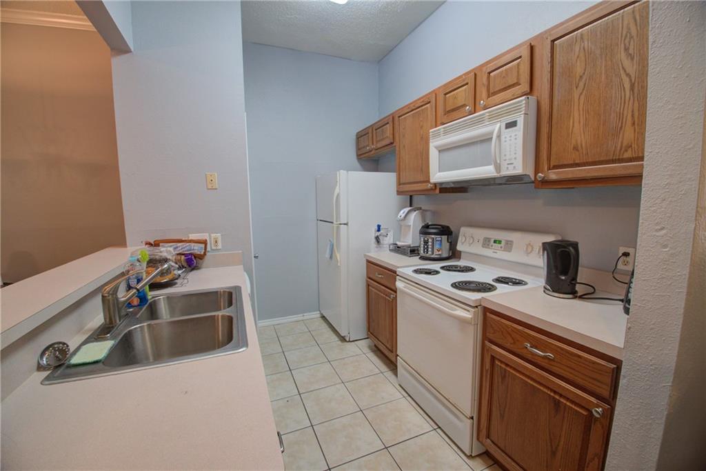 2606 Rio Grande Street, Unit 101 Austin, TX 78705 - Photo 4 of 24 a kitchen with a sink stove and microwave