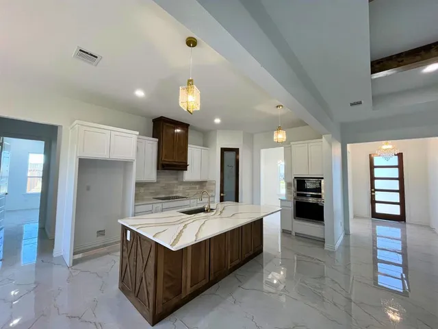 a kitchen with kitchen island a sink stainless steel appliances and cabinets