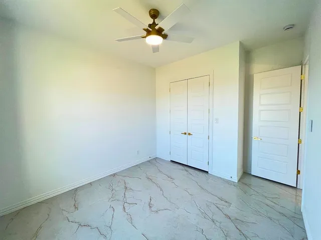 an empty room with fan and a ceiling fan
