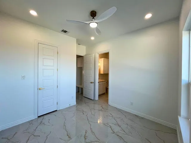 an empty room with closet and a chandelier fan