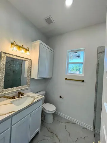 a bathroom with a toilet sink and mirror
