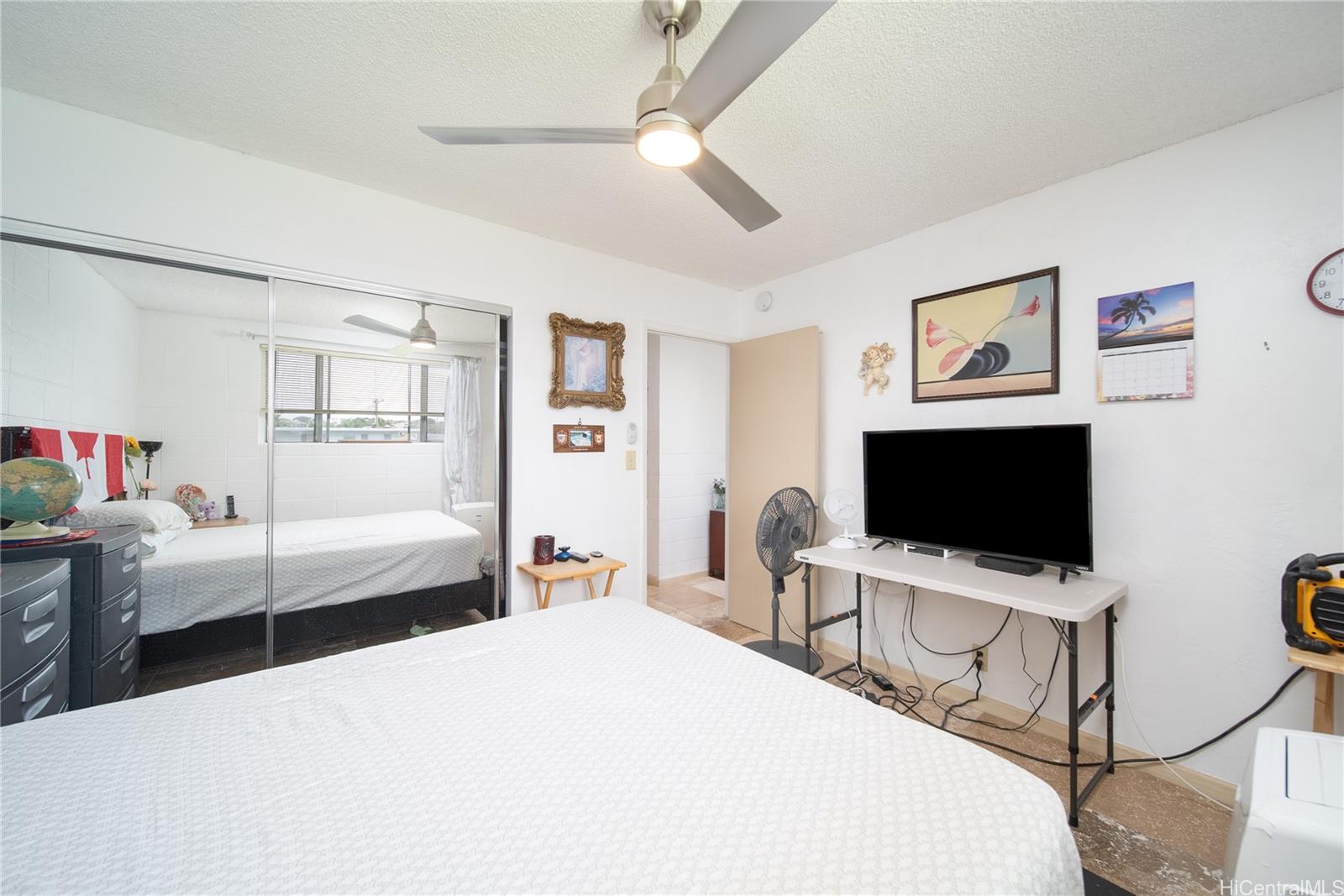 94-011 Waipahu Street, Unit D311 Waipahu, HI 96797 - Photo 11 of 16 a bedroom with a bed and a flat screen tv