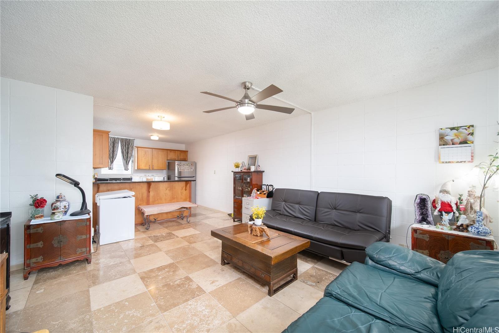 94-011 Waipahu Street, Unit D311 Waipahu, HI 96797 - Photo 2 of 16 a living room with furniture and kitchen view