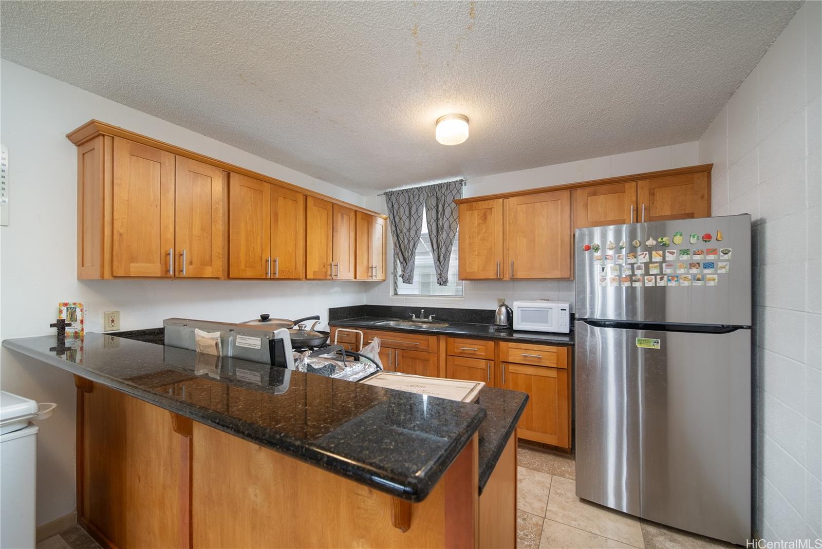94-011 Waipahu Street, Unit D311 Waipahu, HI 96797 - Photo 5 of 16 a kitchen with refrigerator a stove a sink dishwasher and cabinets with wooden floor