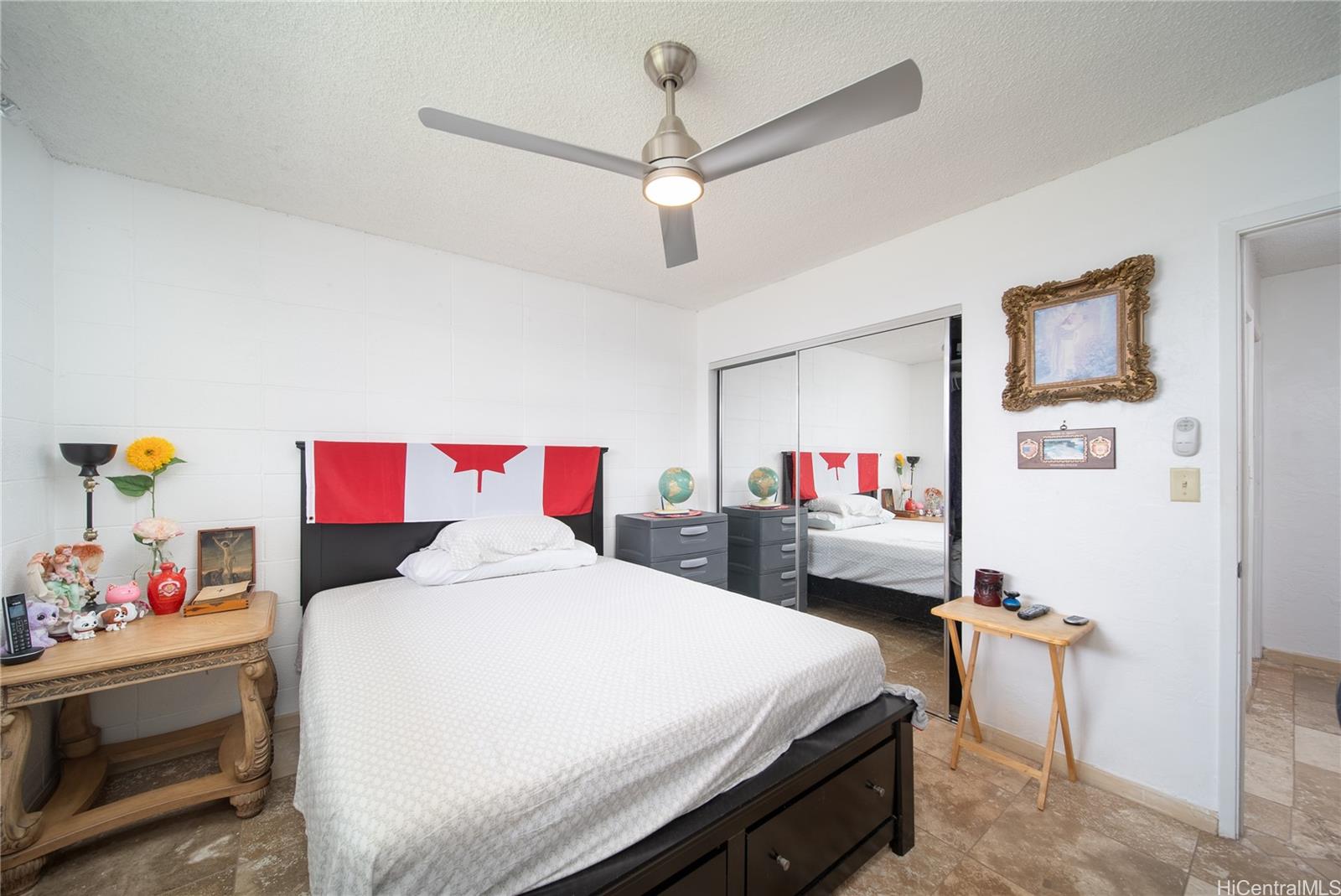 94-011 Waipahu Street, Unit D311 Waipahu, HI 96797 - Photo 8 of 16 a bed room with a bed and a chandelier