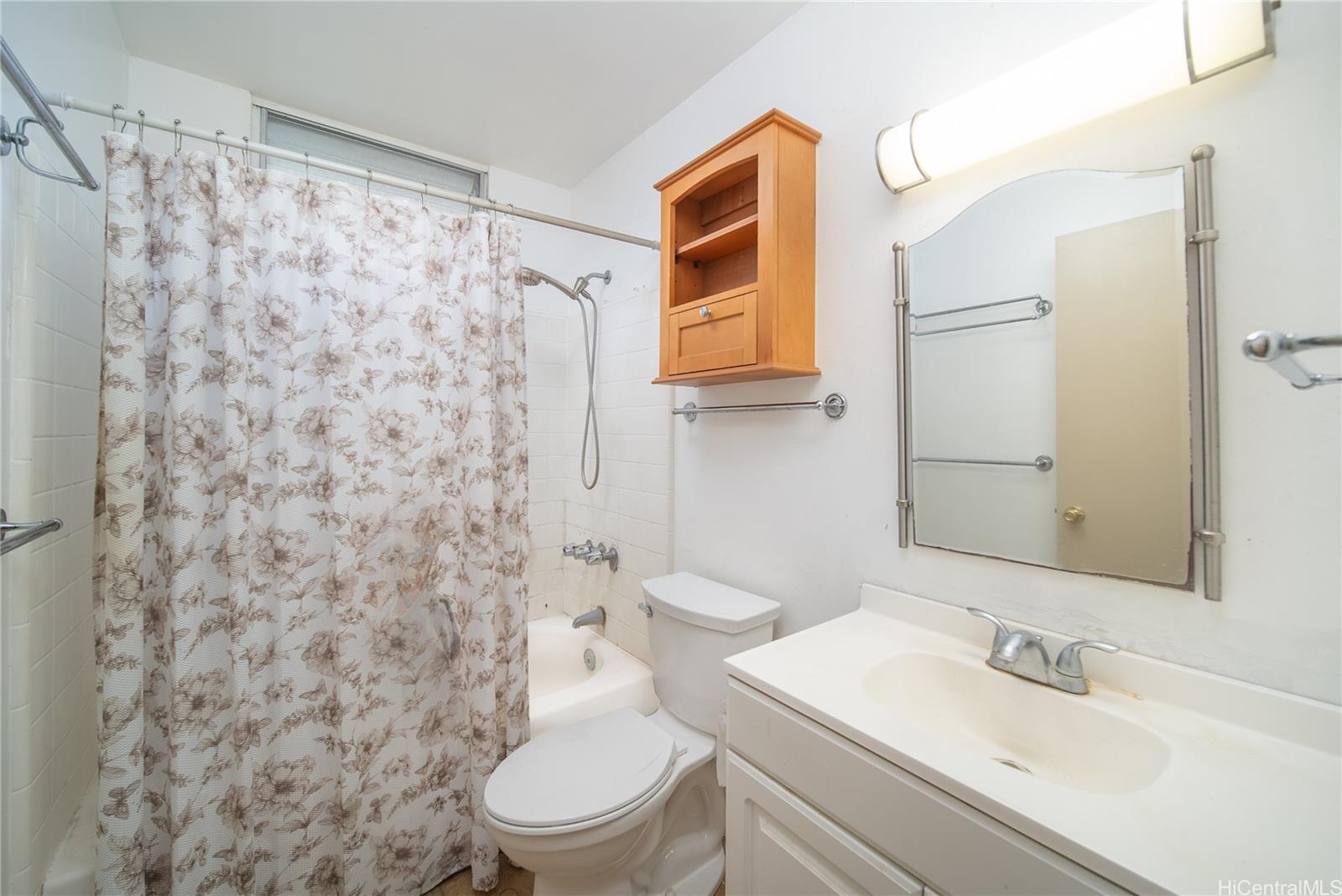 94-011 Waipahu Street, Unit D311 Waipahu, HI 96797 - Photo 9 of 16 a bathroom with a toilet a sink and a mirror