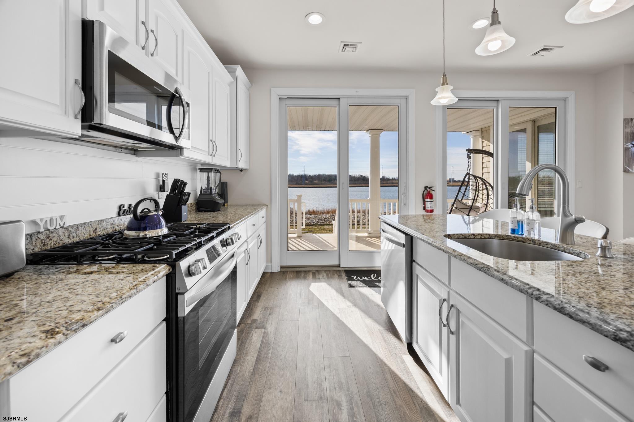 2010 West Riverside Drive Atlantic City, NJ 08401 - Photo 13 of 58 a kitchen with granite countertop a sink a stove cabinets and wooden floor