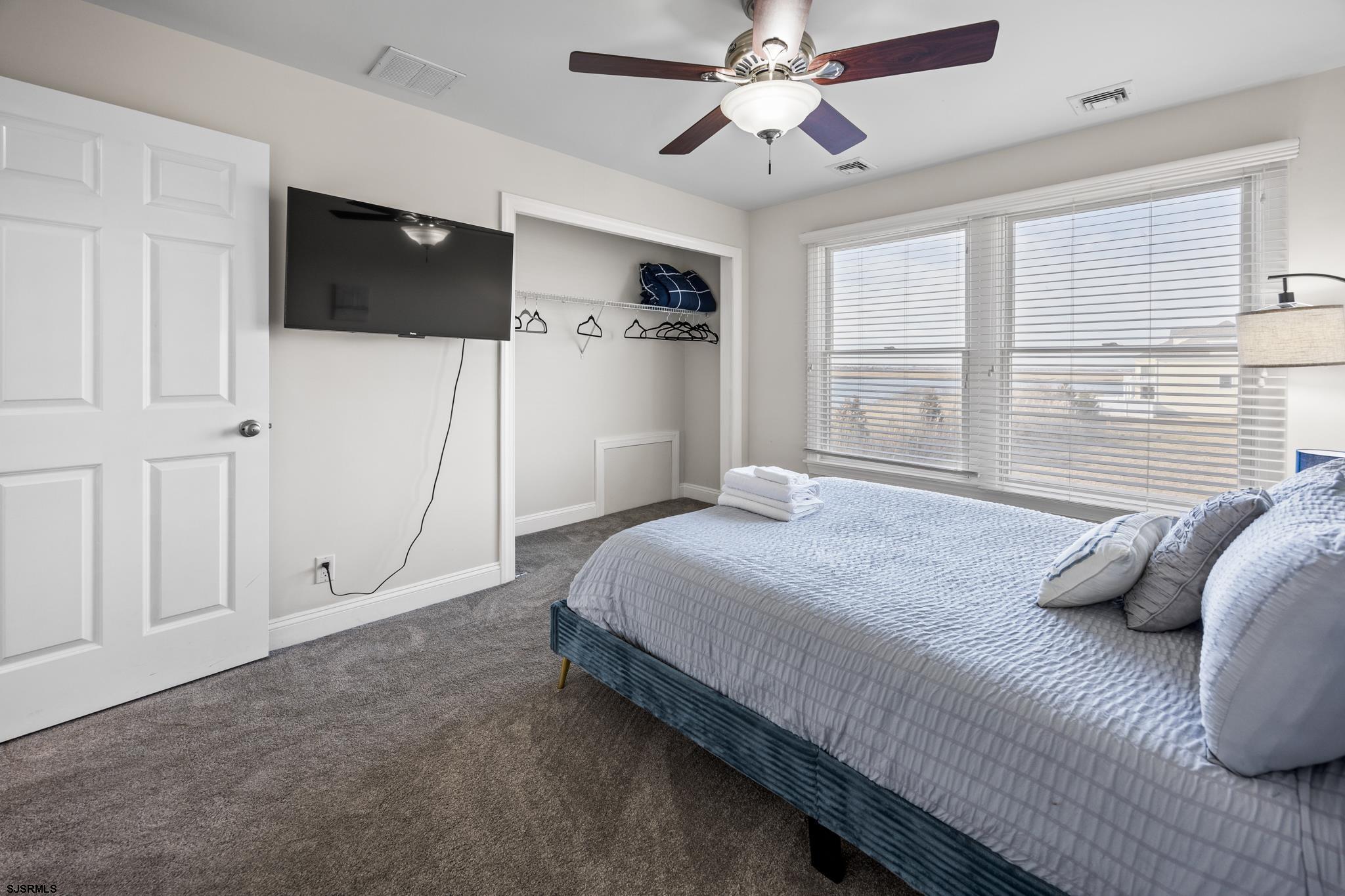 2010 West Riverside Drive Atlantic City, NJ 08401 - Photo 27 of 58 a bedroom with a large bed and a flat tv screen