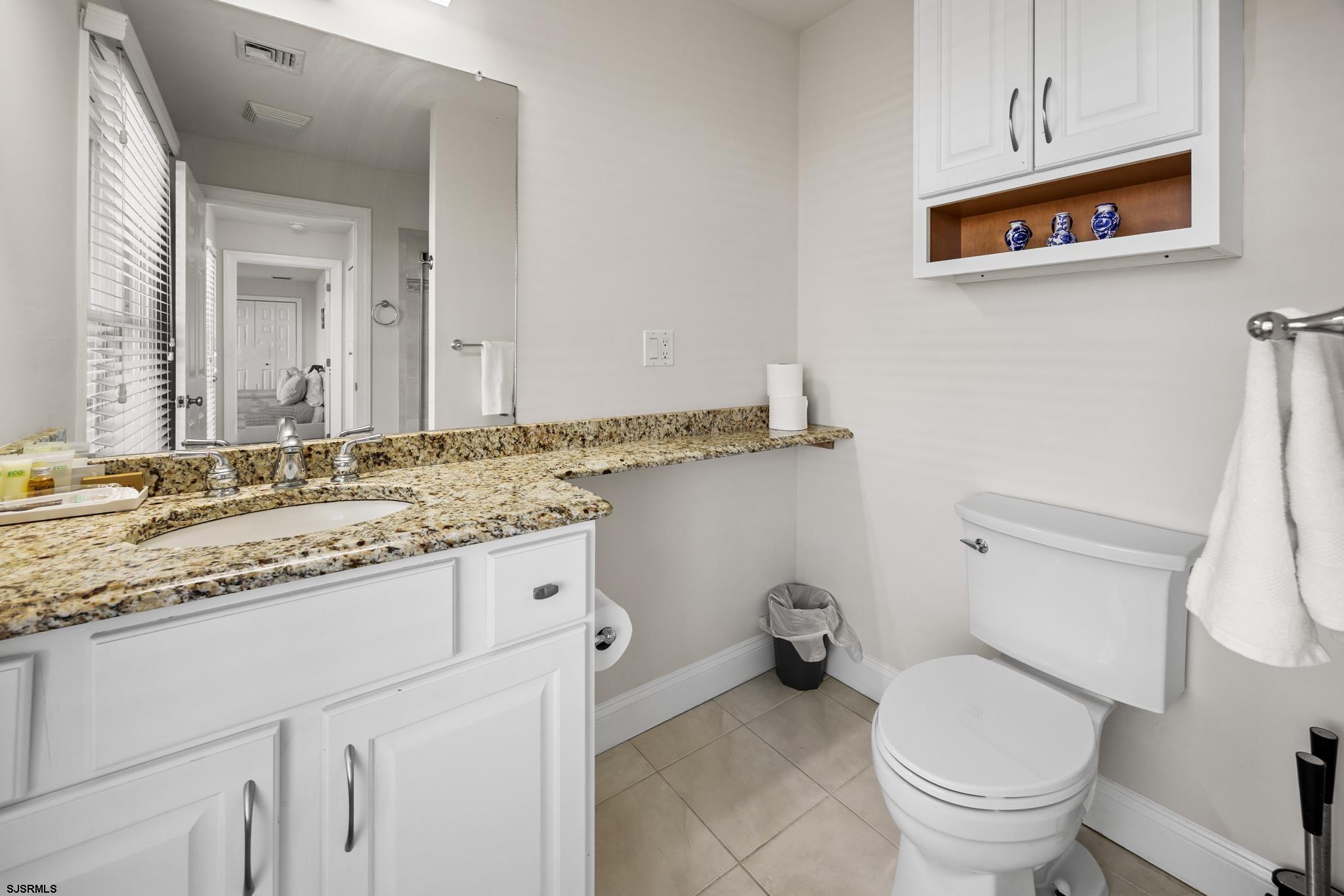 2010 West Riverside Drive Atlantic City, NJ 08401 - Photo 30 of 58 a bathroom with a granite countertop toilet sink and mirror