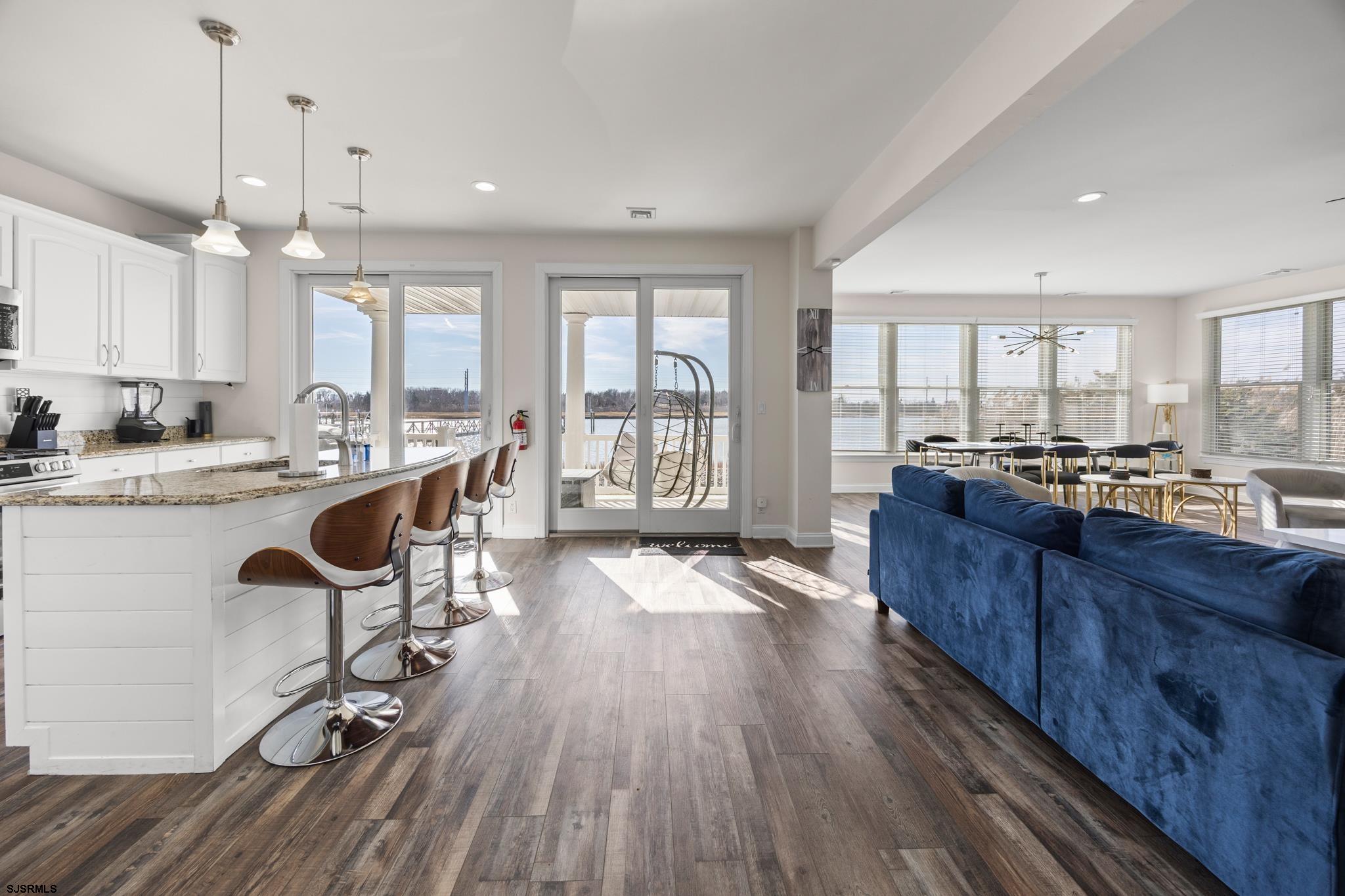 2010 West Riverside Drive Atlantic City, NJ 08401 - Photo 7 of 58 a open kitchen with granite countertop a stove a sink dishwasher a dining table and chairs with wooden floor