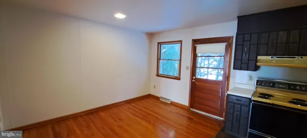 a view of a kitchen with wooden floor and electronic appliances