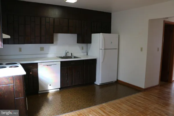 a kitchen with a sink a stove a refrigerator and cabinets