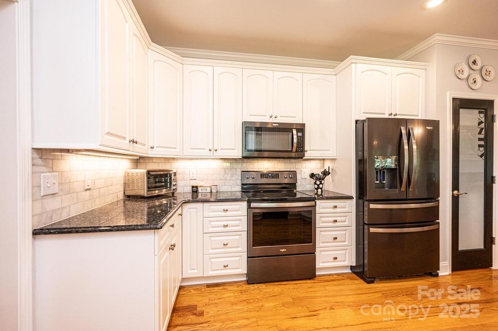 2594 Knoll Ridge Court Hickory, NC 28602 - Photo 11 of 43 a kitchen with granite countertop a refrigerator stove and microwave