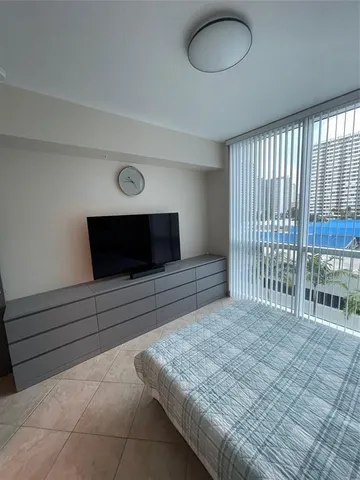 a living room with a bed and a flat screen tv