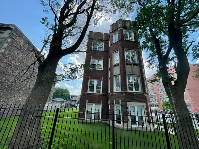 a view of a brick house with a large windows and a large tree