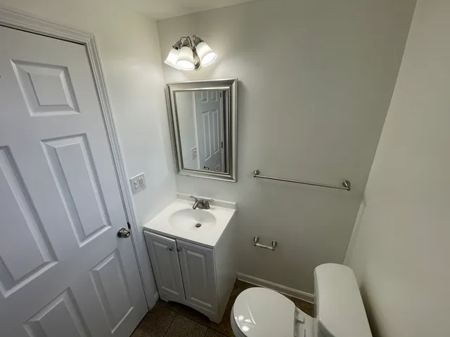 a bathroom with a toilet sink and mirror