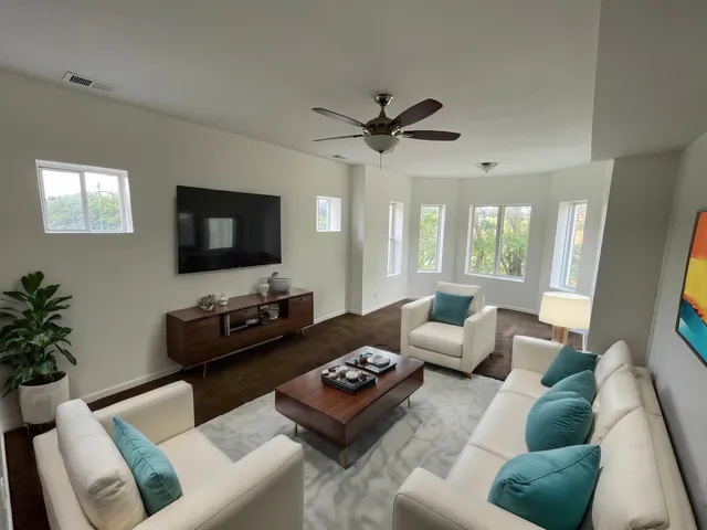 a living room with furniture a flat screen tv and a large window