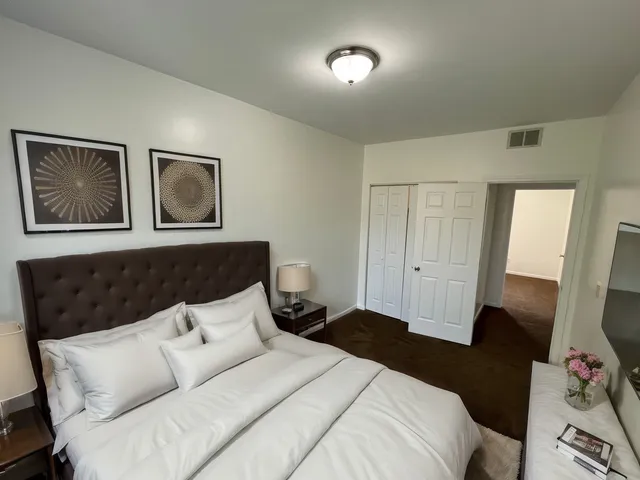 a bedroom with a bed and a flat screen tv