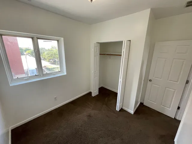an empty room with windows and closet