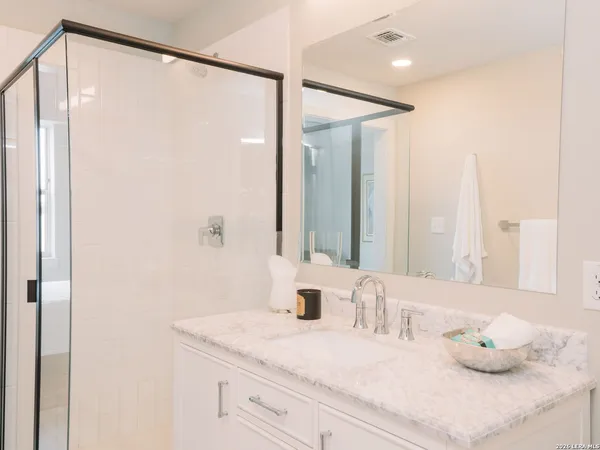 a bathroom with a granite countertop sink and a mirror