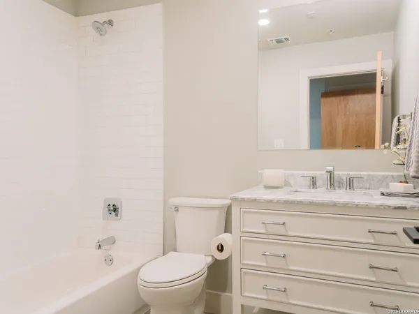 a bathroom with a granite countertop sink a toilet and a bathtub
