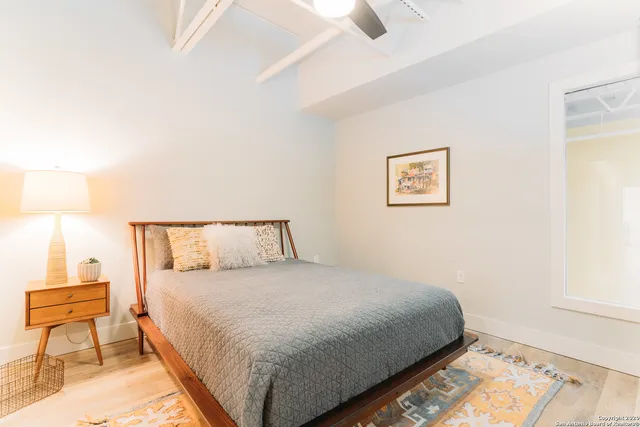 a bedroom with a bed and a lamp on dresser