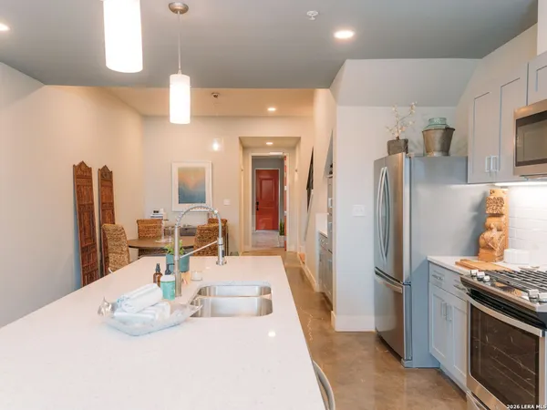 a kitchen with stainless steel appliances kitchen island granite countertop a refrigerator and a sink