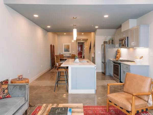 a large kitchen with a table chairs refrigerator and a sink