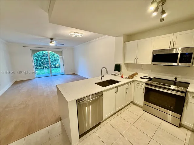 a kitchen that has a sink a stove and a microwave