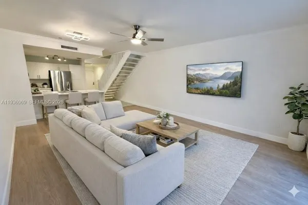 a living room with furniture and wooden floor