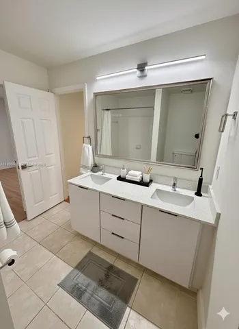a bathroom with a double vanity sink and mirror