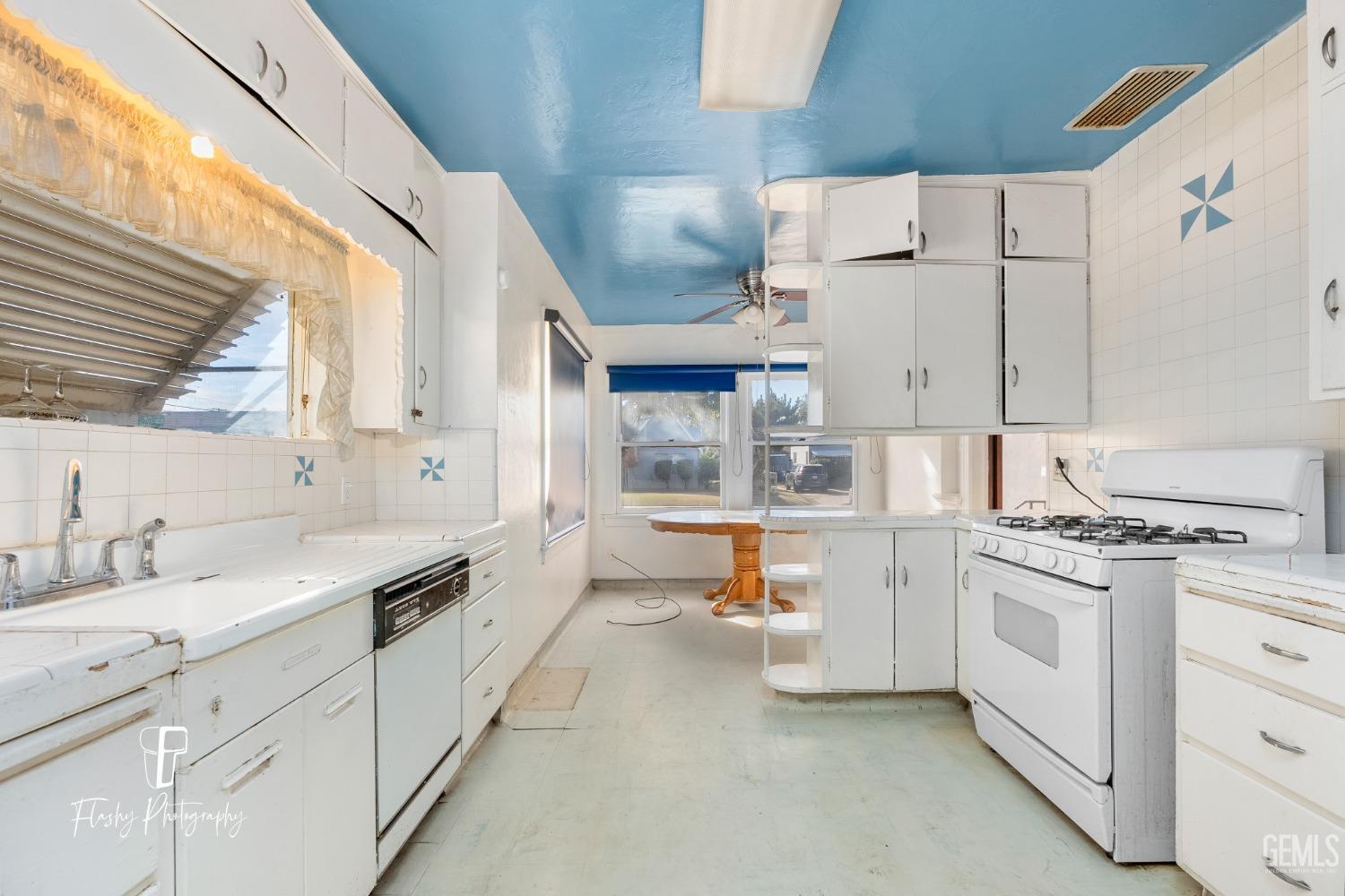Undisclosed Address Bakersfield, CA 93304 - Photo 19 of 38 a kitchen with white cabinets and white appliances