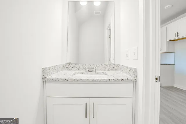 a bathroom with a granite countertop sink and a mirror