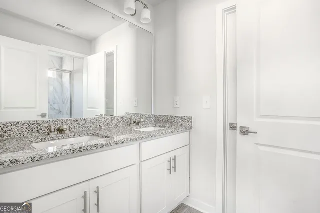 a bathroom with a granite countertop sink and a mirror