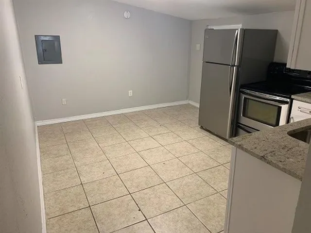 a kitchen with white cabinets a refrigerator and a sink