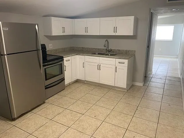 a kitchen with a sink cabinets and a refrigerator