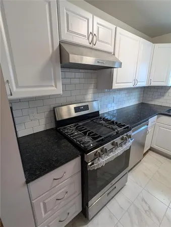 a stove top oven sitting inside of a kitchen