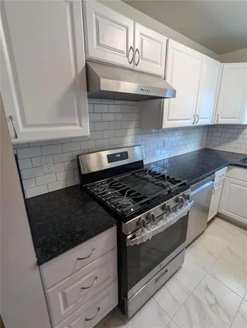 a stove top oven sitting inside of a kitchen