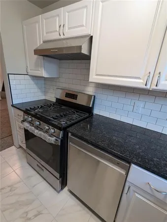 a kitchen with granite countertop a stove and a sink
