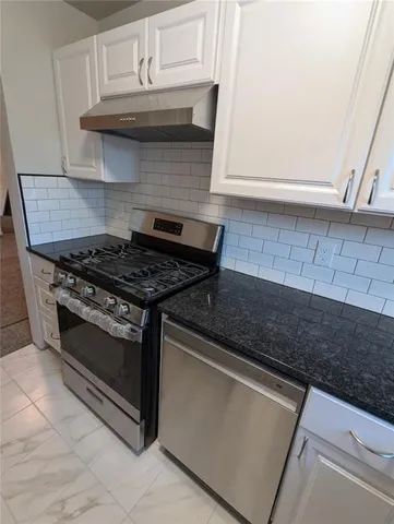 a kitchen with granite countertop a stove and a sink