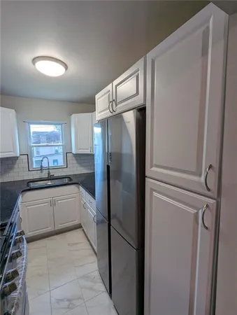 a large kitchen with a refrigerator and a sink