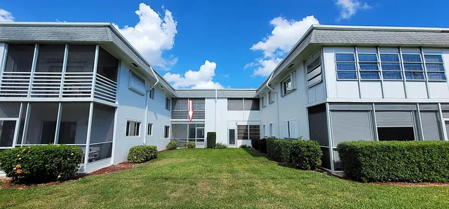 a view of a house with many windows and plants