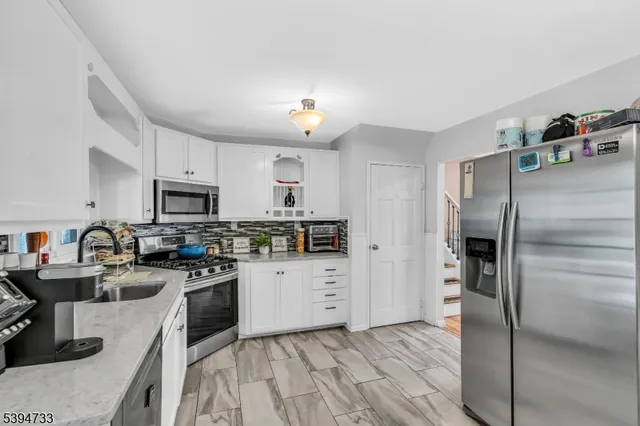 a kitchen with granite countertop stainless steel appliances and wooden cabinets