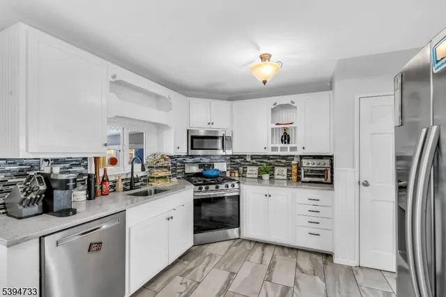 a kitchen with a sink stainless steel appliances and white cabinets