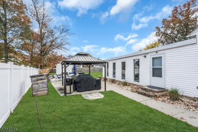 a view of a house with backyard and sitting area