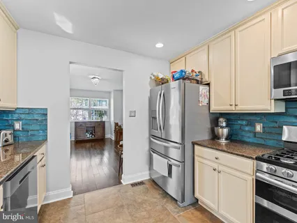 a kitchen with stainless steel appliances granite countertop a refrigerator stove and sink