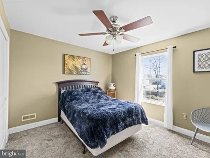 a bedroom with a bed rug and wooden floor