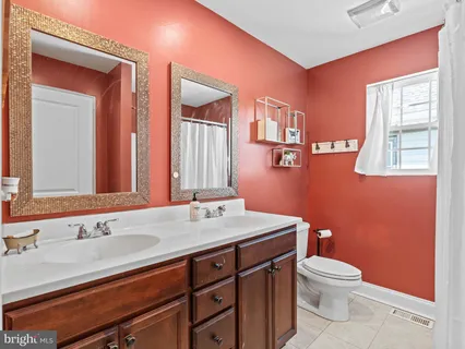 a bathroom with a granite countertop toilet sink and mirror
